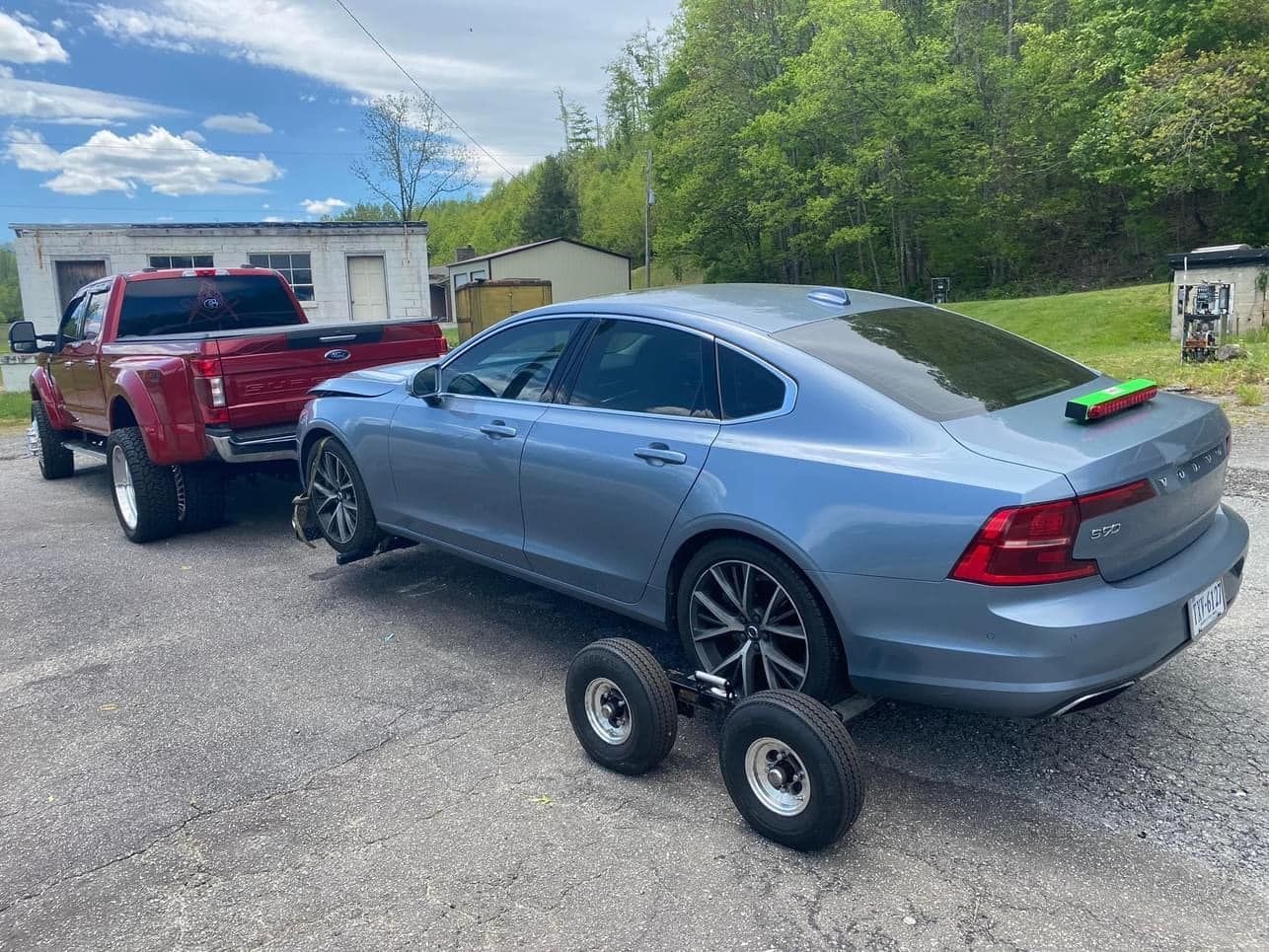 Red Big Toe's dually towing a Volvo sedan on wheel dollies
