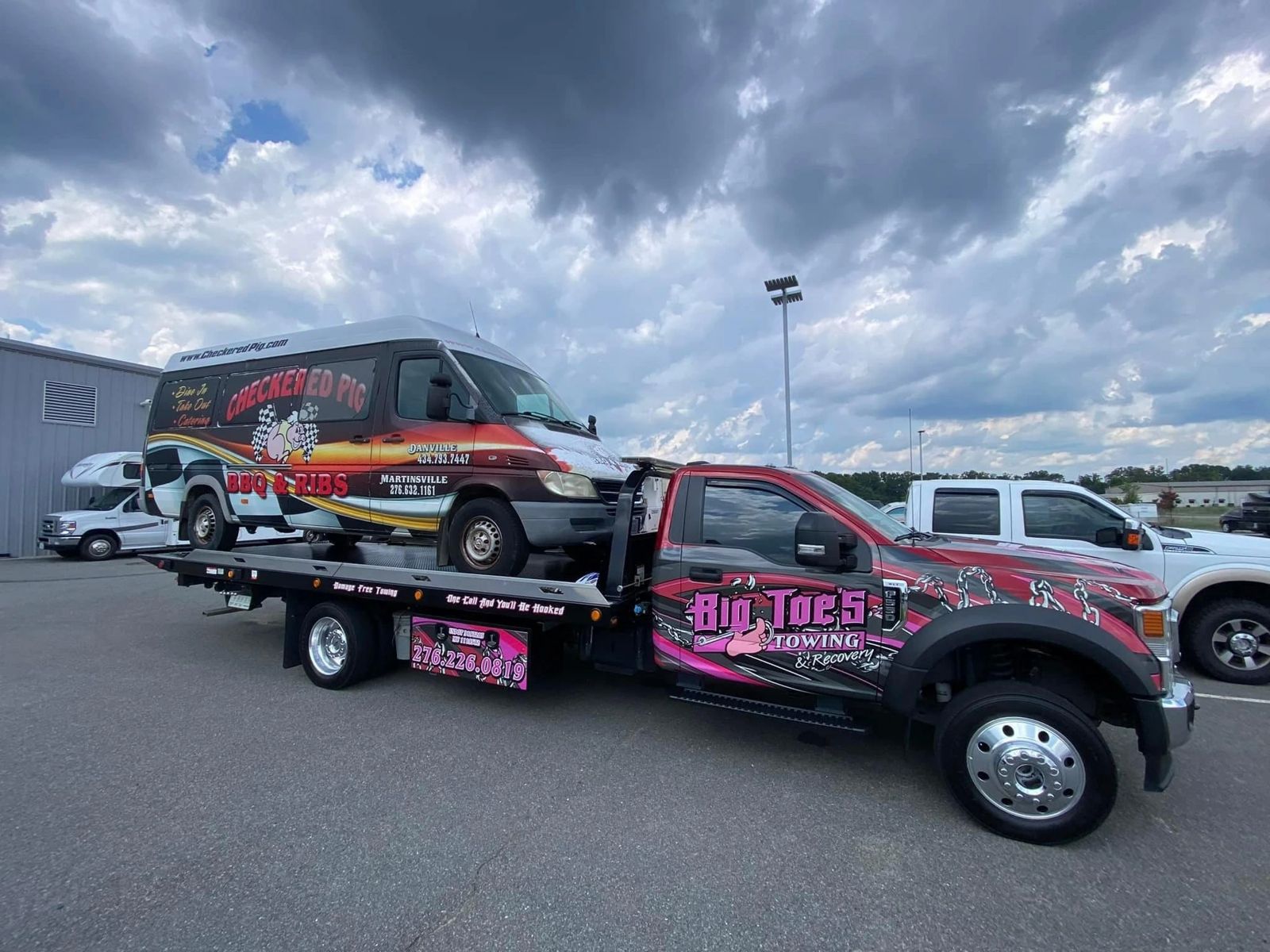 Big Toe's flatbed hauling a Checkered Pig BBQ van